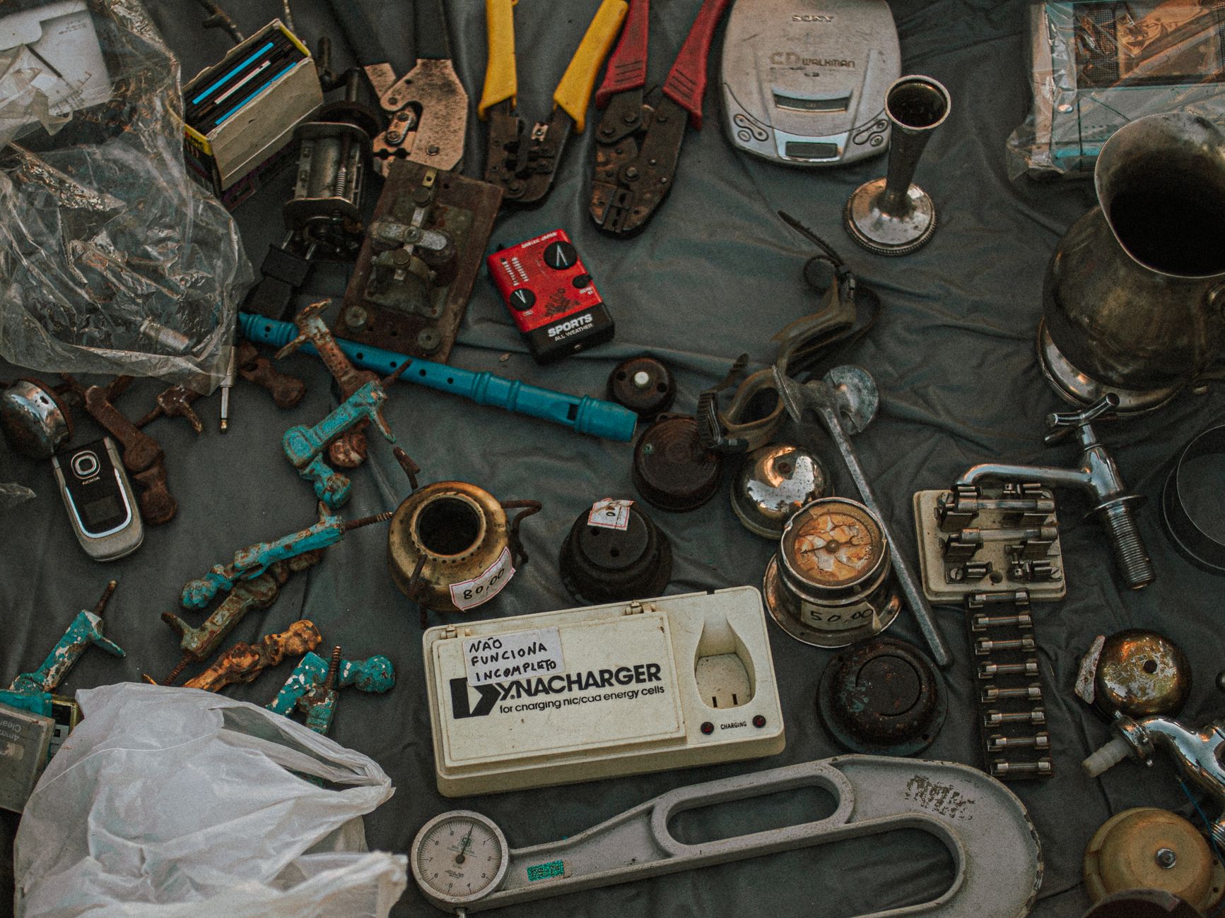 An open drawer of assorted old smartphones and chargers